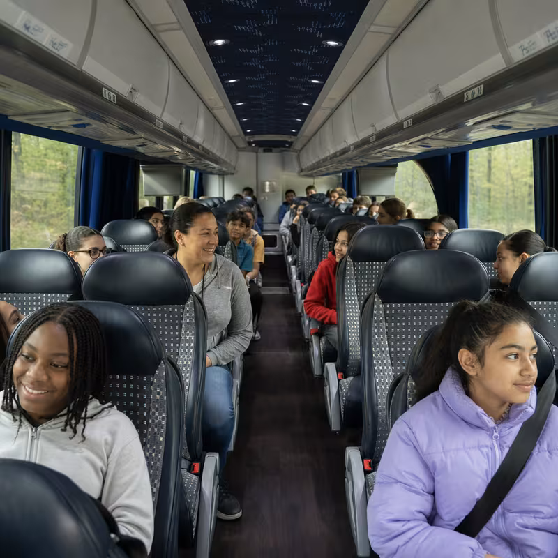 Group boarding a white charter bus for School Transportation transportation in Washington